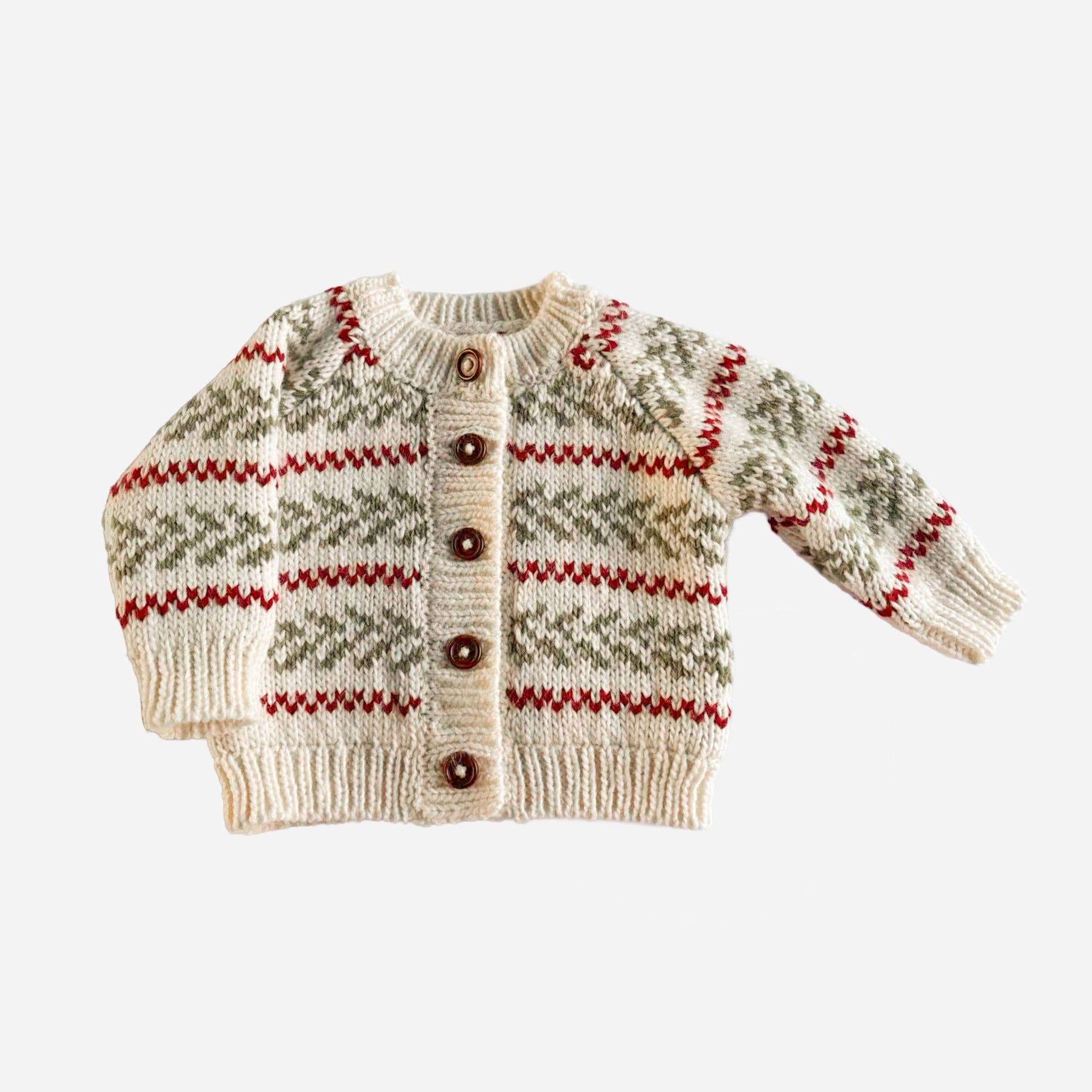 The Blueberry Hill Evergreen hand-knit cardigan in cream with green pine sprigs and red stripes