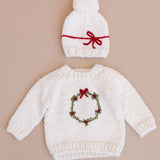 Child wearing the cream Wreath Sweater for the holidays