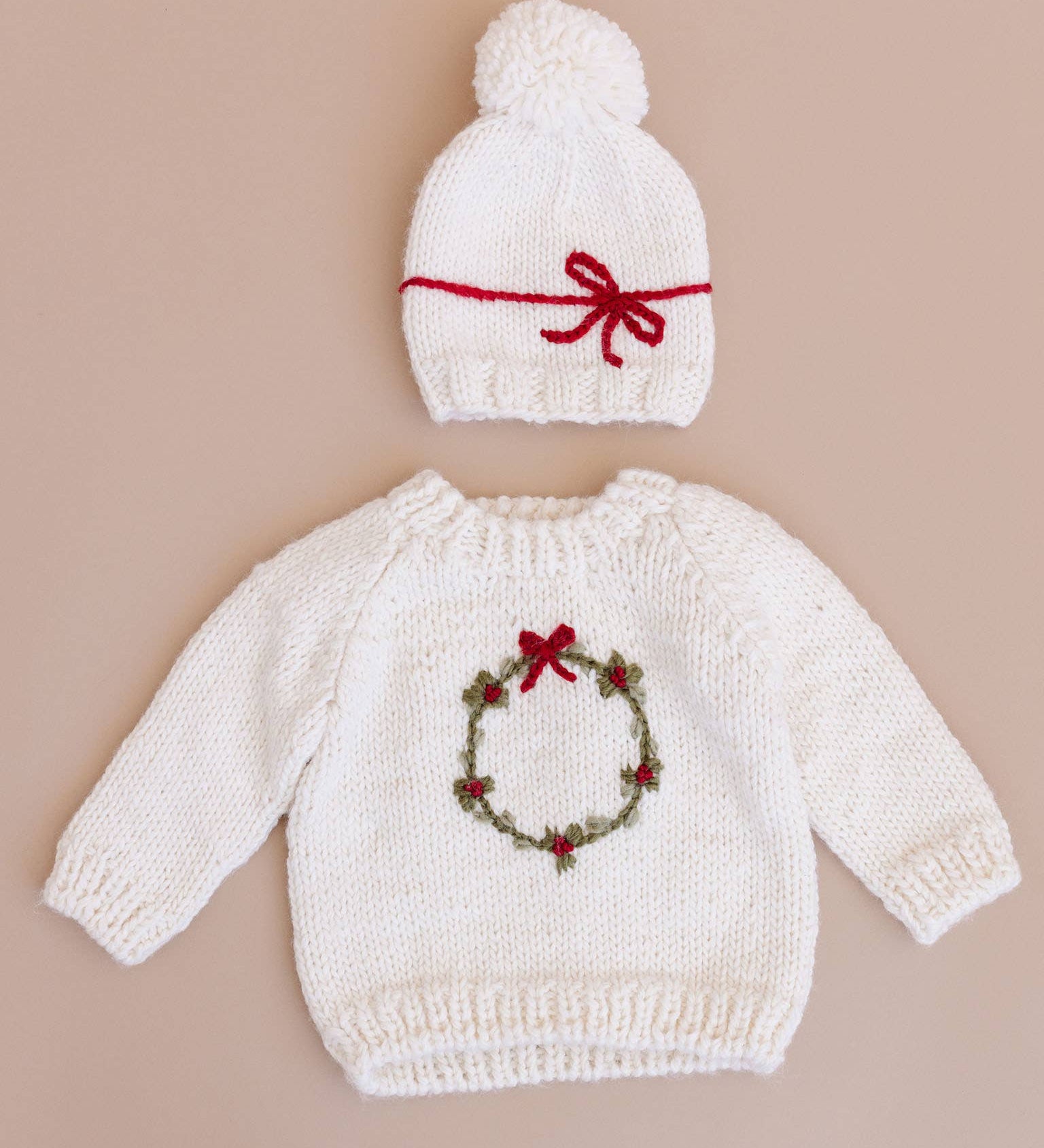Child wearing the cream Wreath Sweater for the holidays