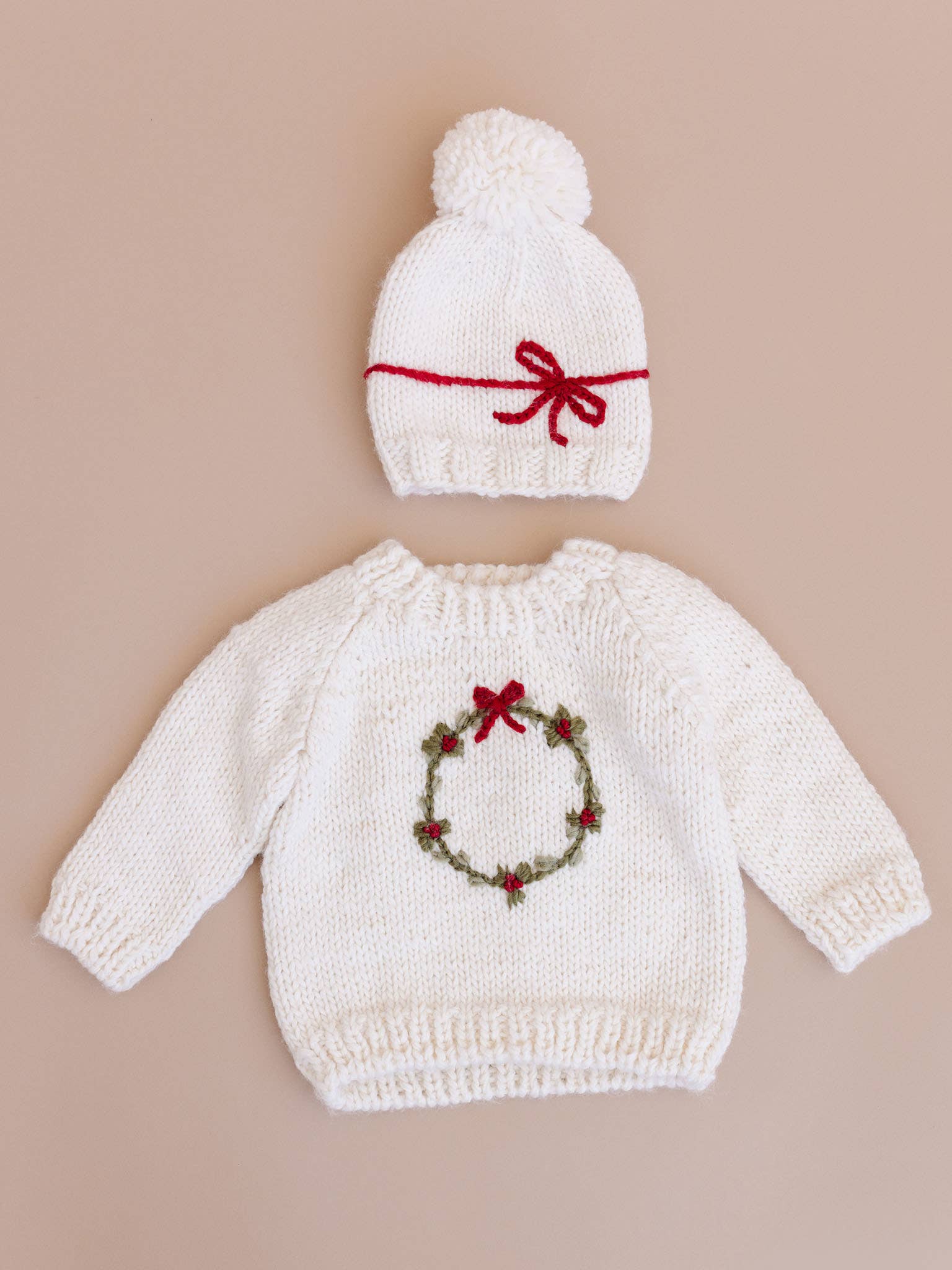 Child wearing the cream Wreath Sweater for the holidays