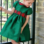 Girl wearing Susanne Lively green taffeta dress with plaid collar and sash