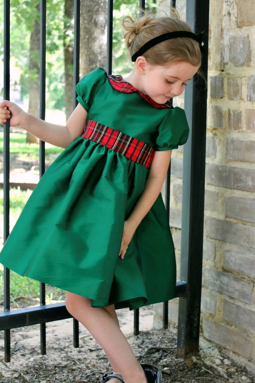 Girl wearing Susanne Lively green taffeta dress with plaid collar and sash