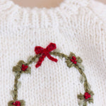 Close-up of the embroidered wreath, red berries and bow on the Wreath Sweater
