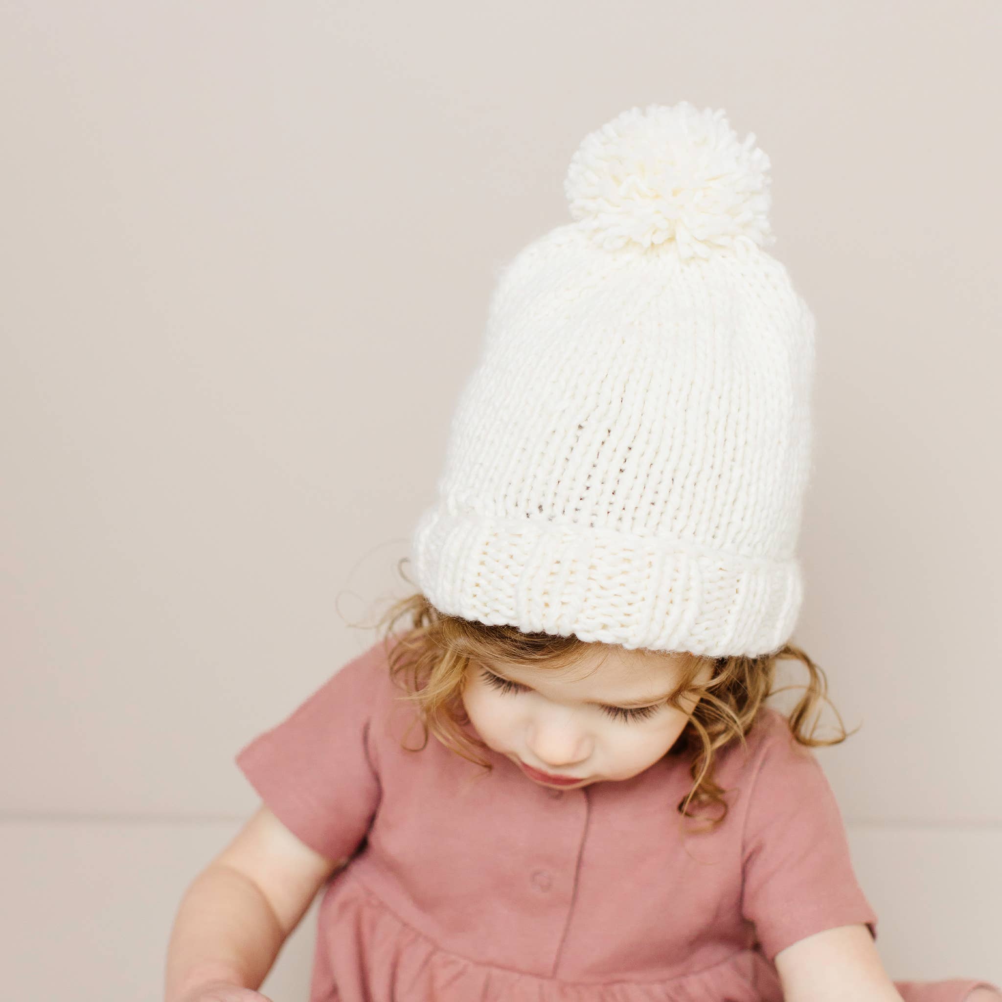 Close-up of the cream Classic Pom Hat knit and pom