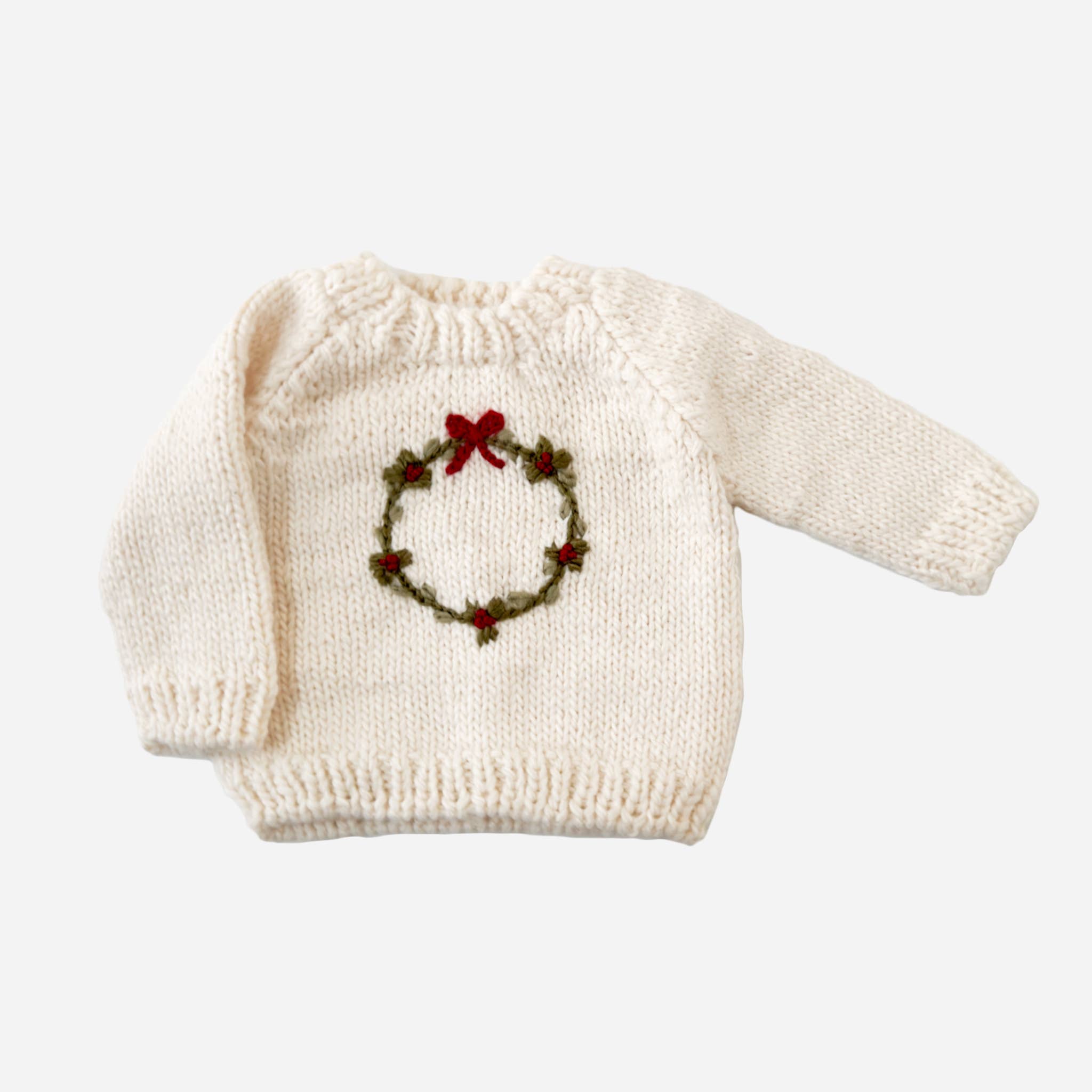The Blueberry Hill cream hand-knit Wreath Sweater with embroidered green wreath and red berries