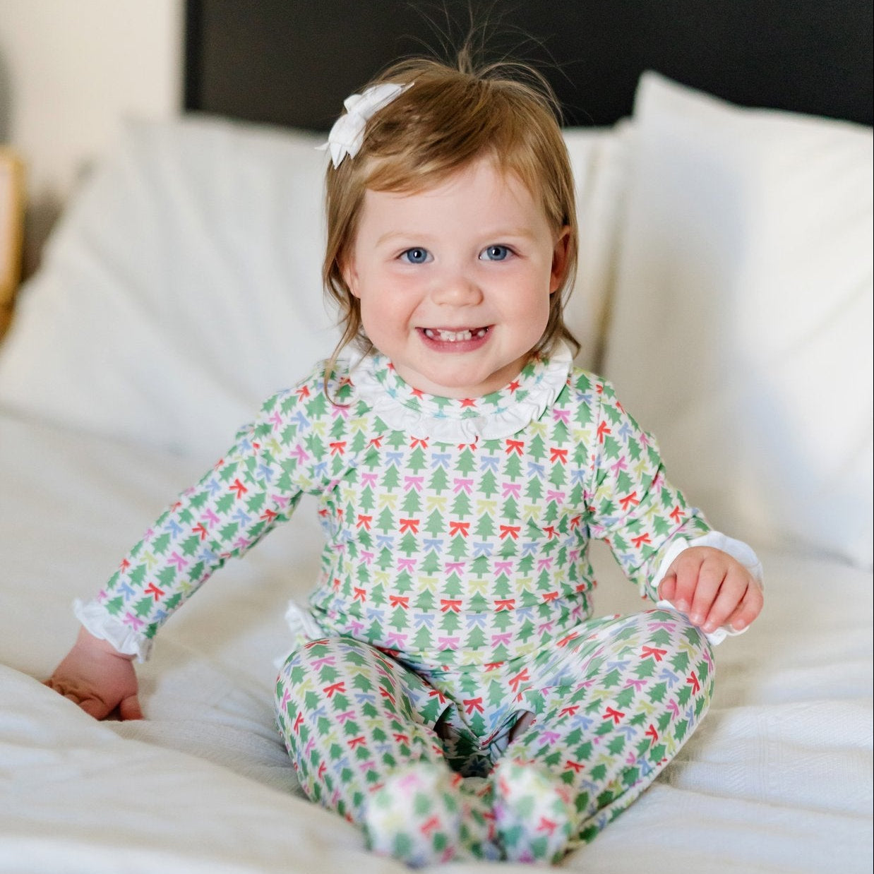 Baby wearing the Lucy romper in Tree Topper Bows