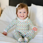 Baby wearing the Lucy romper in Tree Topper Bows