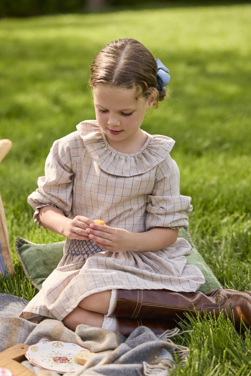 Girl wearing the Little English Smocked Molly Skirt in Durham Windowpane with the coordinating Bespoke Blouse