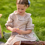 Girl wearing the Little English Smocked Molly Skirt in Durham Windowpane with the coordinating Bespoke Blouse