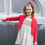 Rachel Riley Apple Blossom smocked dress styled with a red cardigan