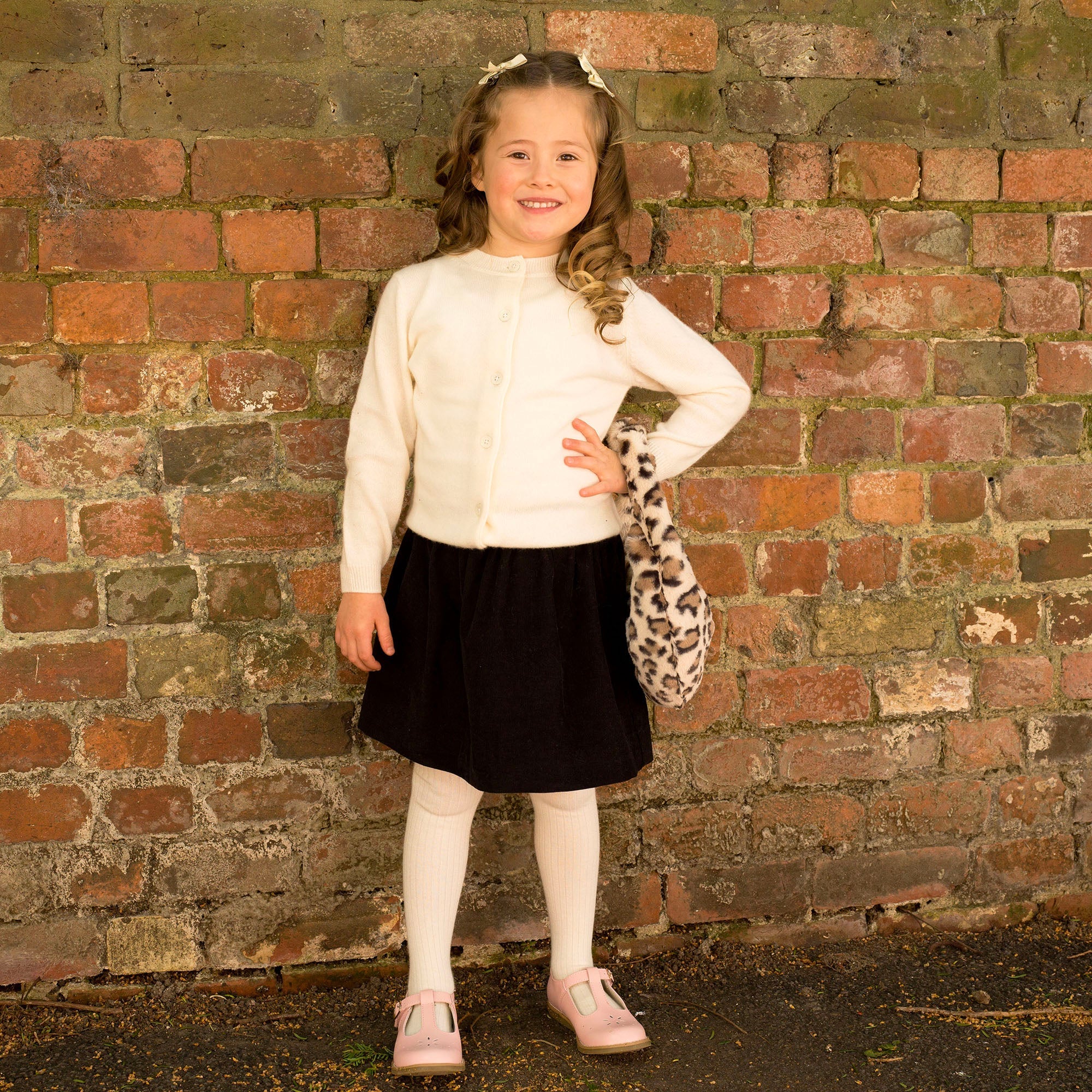 Rachel Riley black corduroy skirt styled with an ivory cardigan
