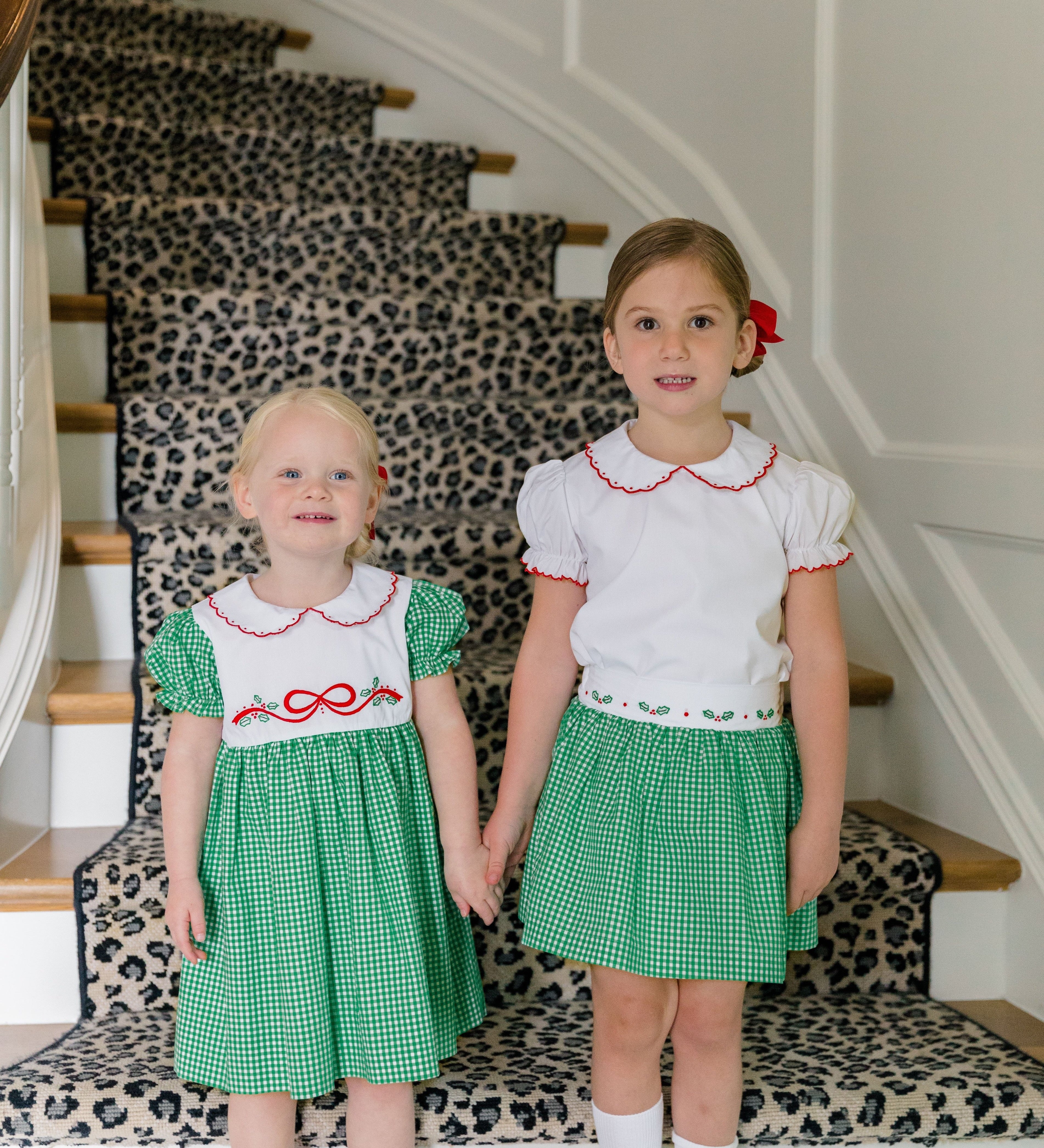 Girl wearing the Carol Christmas Skirt in green gingham with holly trim