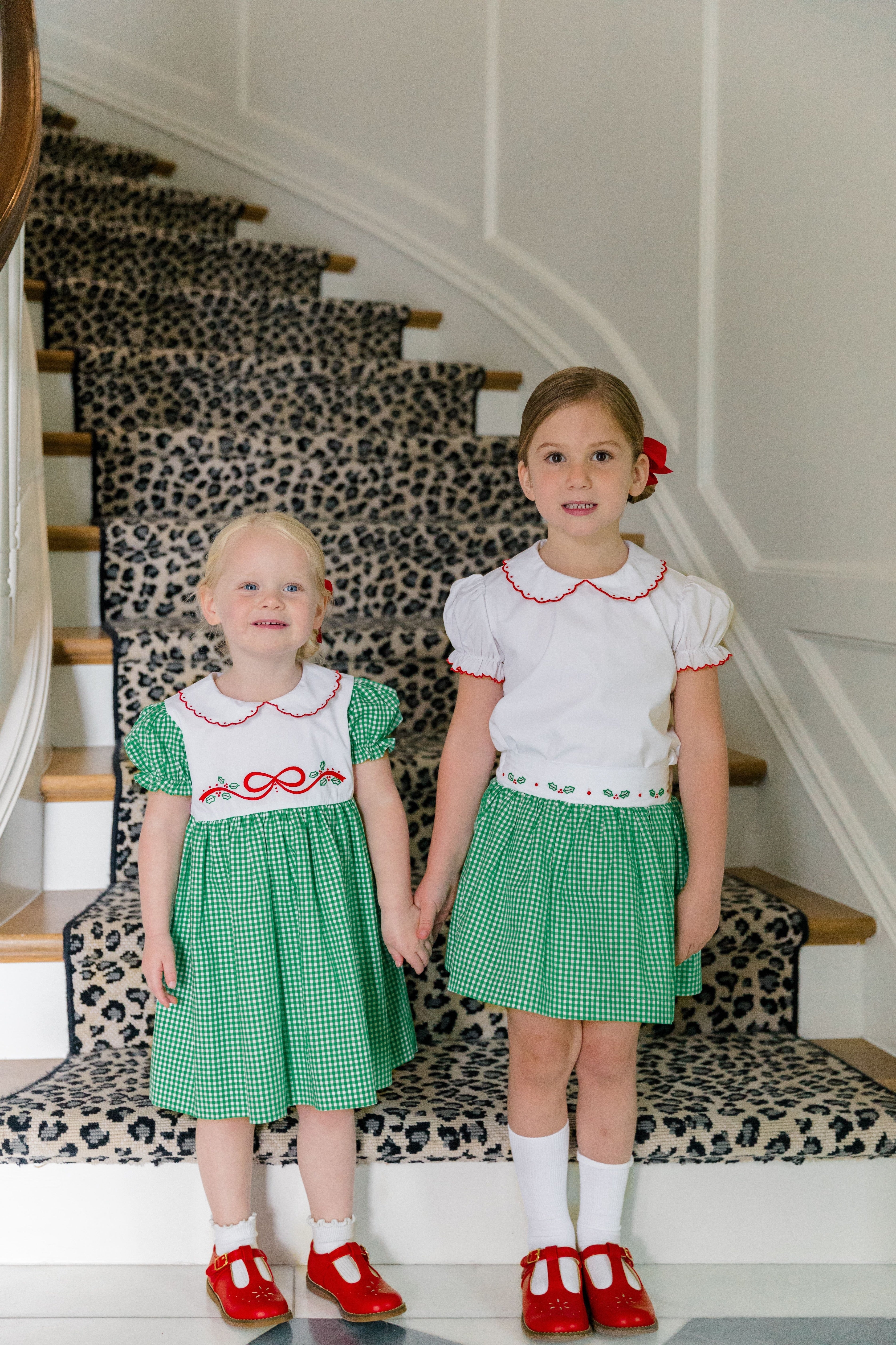 Girl wearing the Carol Christmas Skirt in green gingham with holly trim