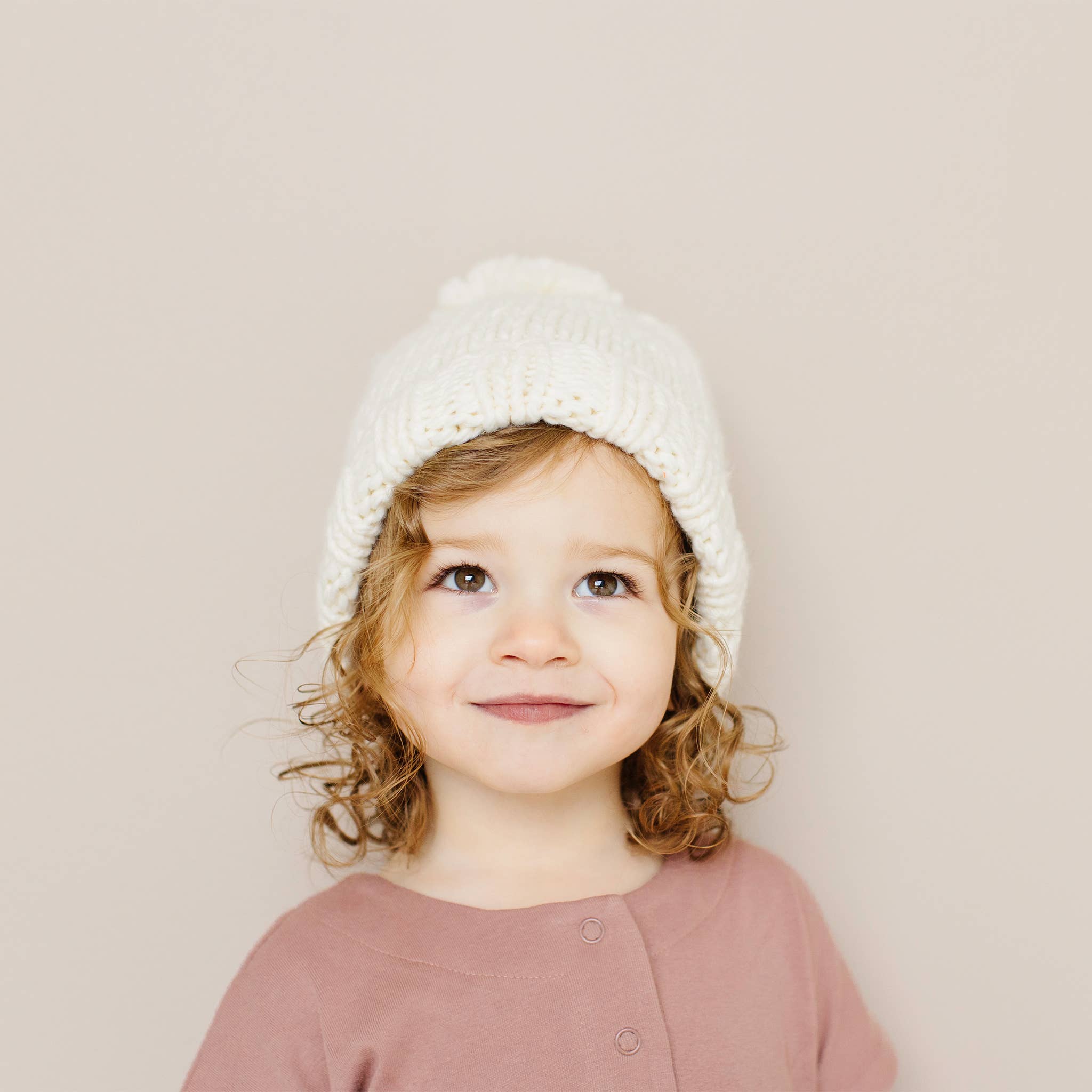 Baby wearing the cream Classic Pom Hat